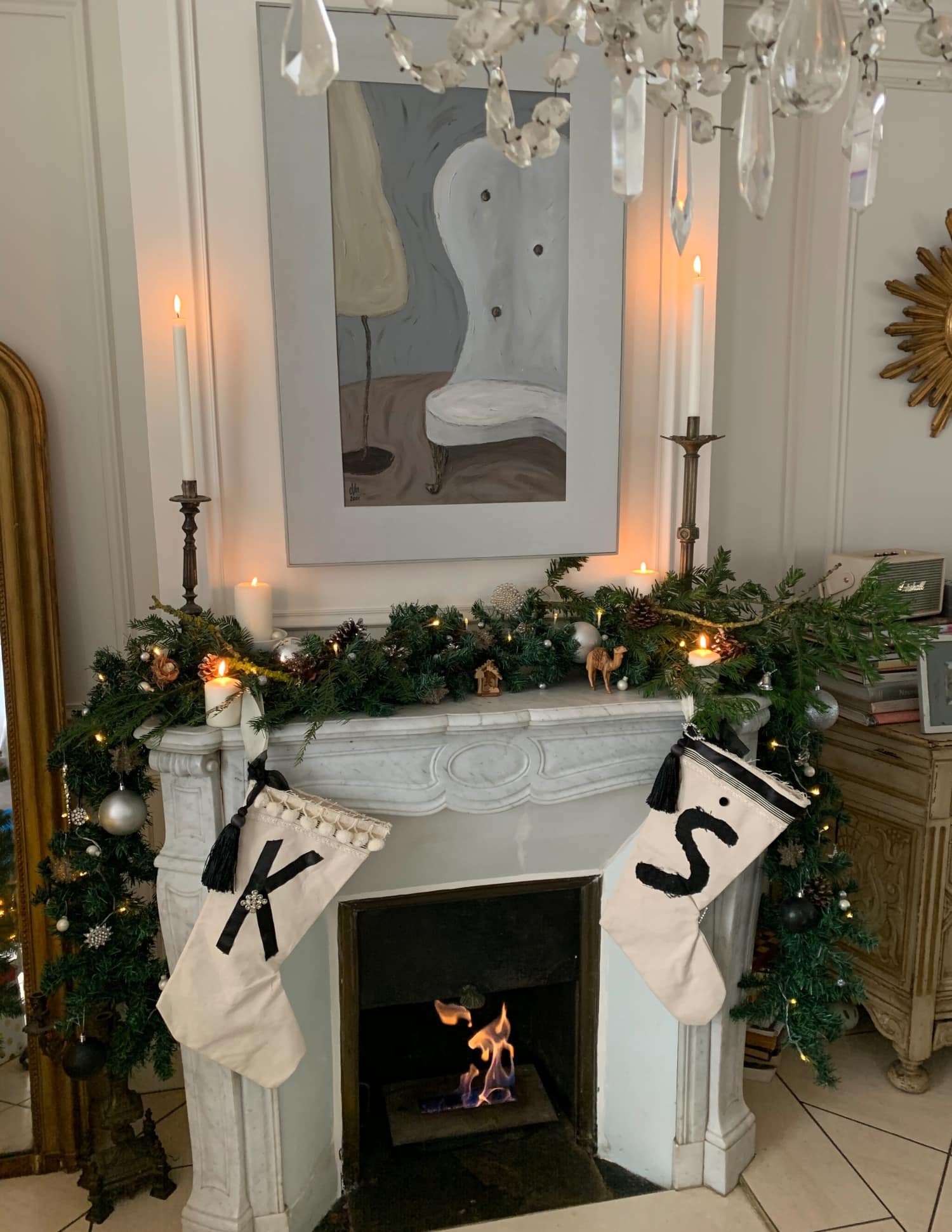 Artist Cheryl Hironaka's mantel is decked out in the foliage of the season. Above it is her own painting, crowning the scene. Of the Christmas stockings, she says, "The white socks with black letters K and S, my son’s initials are handmade by me using different materials I can find around the house, I added some vintage brooches to add a bit of glam. I don’t have a sewing machine nor wouldn’t know how to use one that’s why they look a bit shabby." Artist Cheryl Hironaka's mantel is decked out in the foliage of the season. Above it is her own painting, crowning the scene. Of the Christmas stockings, she says, "The white socks with black letters K and S, my son’s initials are handmade by me using different materials I can find around the house, I added some vintage brooches to add a bit of glam. I don’t have a sewing machine nor wouldn’t know how to use one that’s why they look a bit shabby."